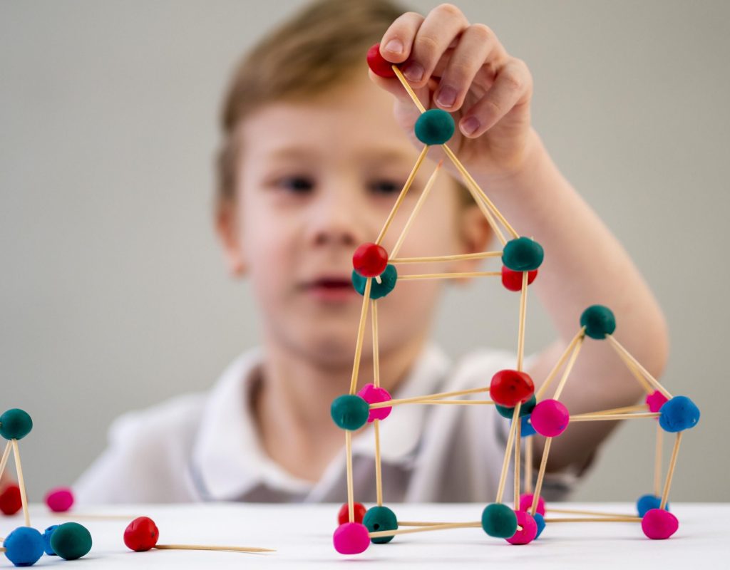 boy-playing-with-colorful-atoms-game-table